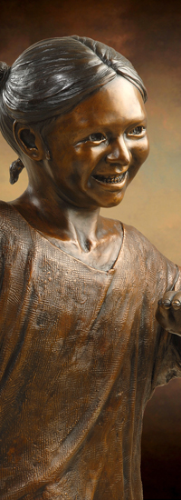 Smiling Girl Bronze Statue, part of Welcoming Christ sculpture scene of Jesus and Children, by Tom White, sculptor.