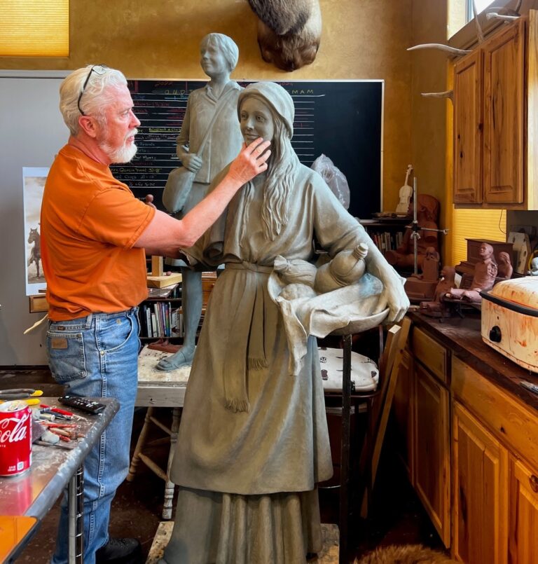 Sculptor shaping life-size female statue in studio Sculptor shaping life-size female statue in studio