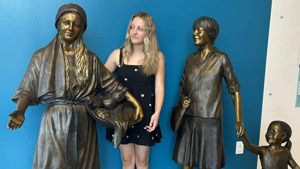 Saint Angela Merici Statue & Dorothy Kazel bronze portrait sculpture scene commissioned by Urban Community School and created by Tom White, Sculptor. St Angela Merici was the founder of the Ursuline nuns in the 1400&rsquo;s. Photo with Isabella, the artist's granddaughter who posed for the sculpture.